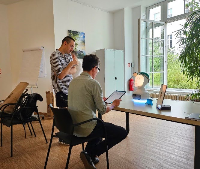 Two people infront of the Software. Two tablets, one showing the questionnaire, and one showing the virtual avatar